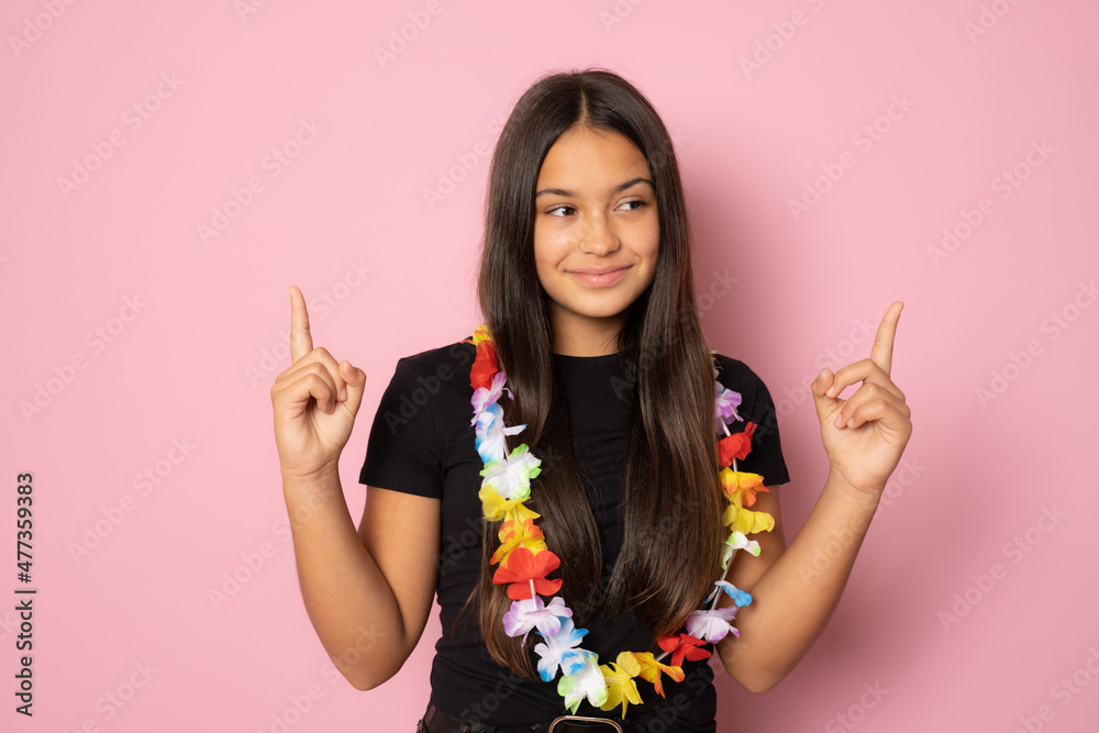 Brunette smiling hispanic girl pointing fingers up over pink background. Brunette smiling hispanic girl pointing fingers up over pink background.