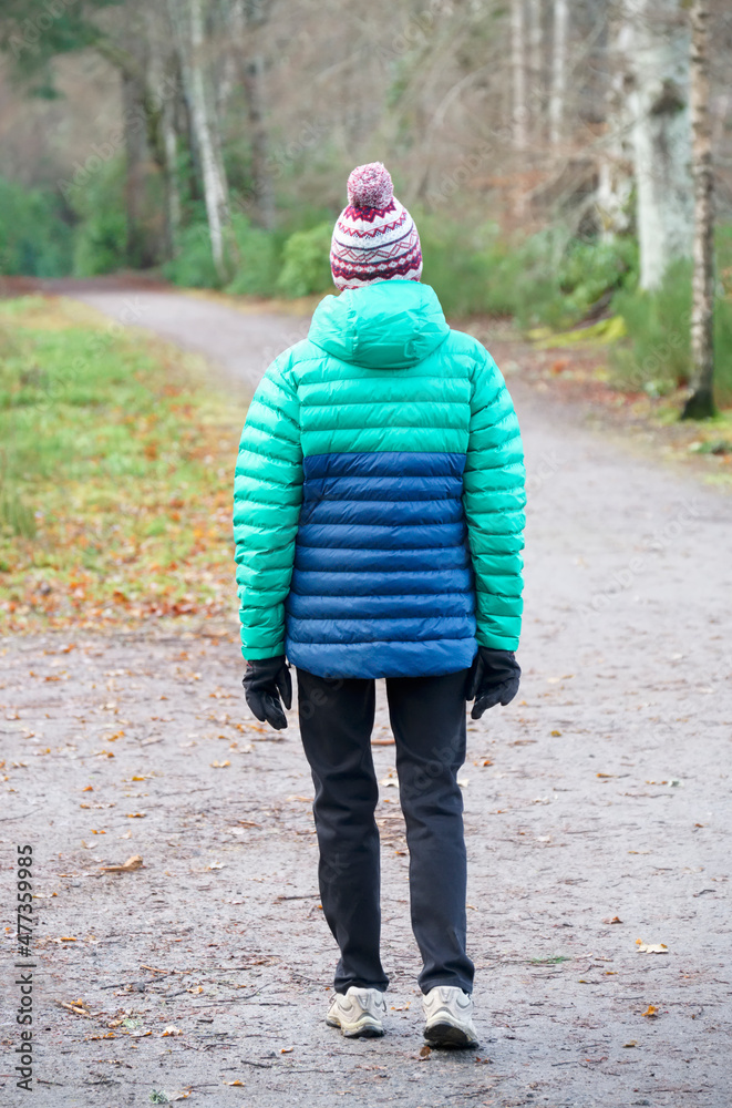Fototapeta premium Single elderly woman walking alone in forest for good mental and physical health
