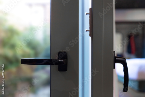 Metal door frame closeup view, Aluminum glass window and handle detail, blur outdoor background