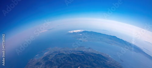 Fototapeta Naklejka Na Ścianę i Meble -  Curvature of planet earth. Aerial shot. Blue sky and clouds over island in the ocean