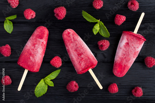 Top view of popsicles with raspberry on the black wooden  background. Close-up. photo