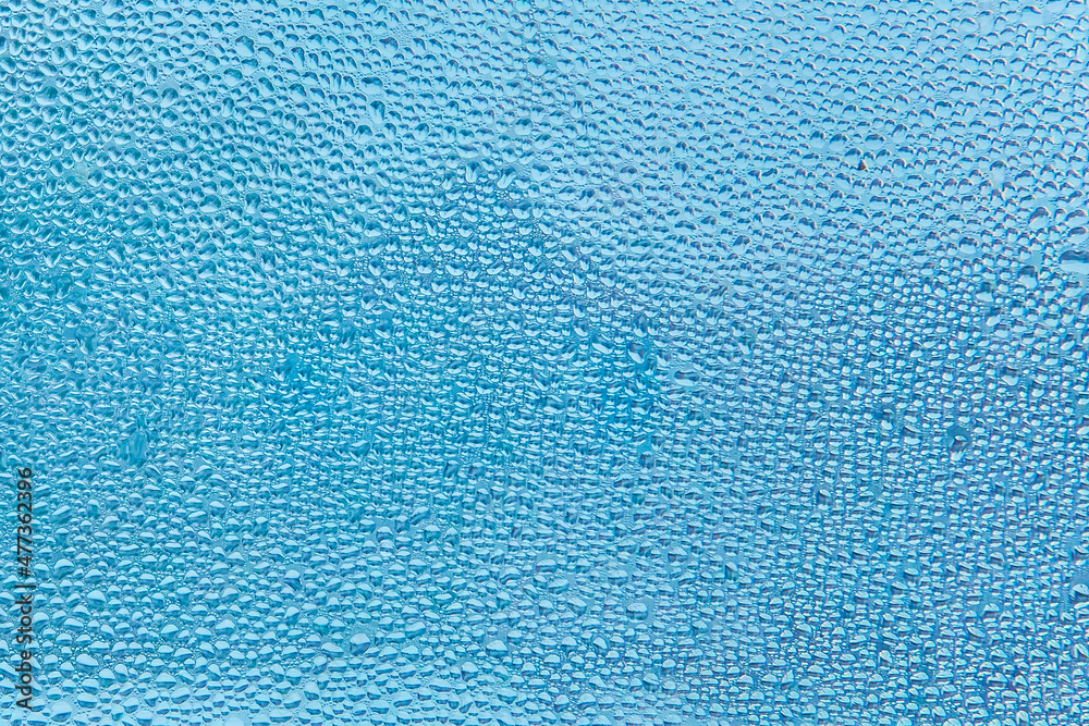 Cold blue water drops on glass window texture, winter background Cold blue water drops on glass window texture, winter background