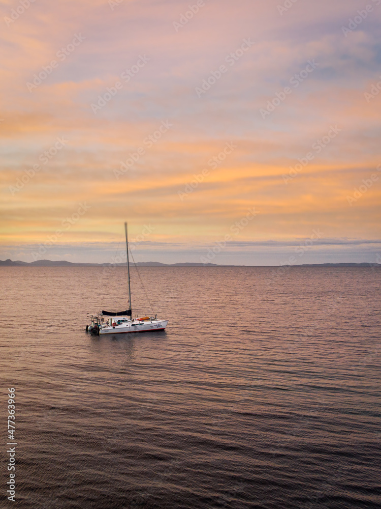 Fototapeta premium Catamaran au lever du soleil devant l'ile de Porquerolles sur la côte d'Azur - Catamaran with sunrise from the coastal path near Porquerolles - Azur Coast