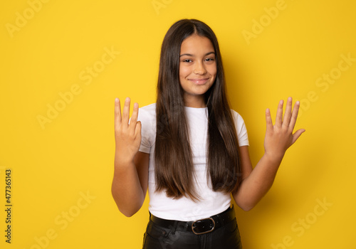 Brunette hispanic girl showing and pointing up with fingers number eight while smiling confident and happy.