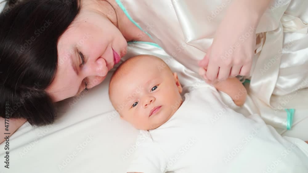 mom lies with the baby in bed. the happiness of motherhood. 