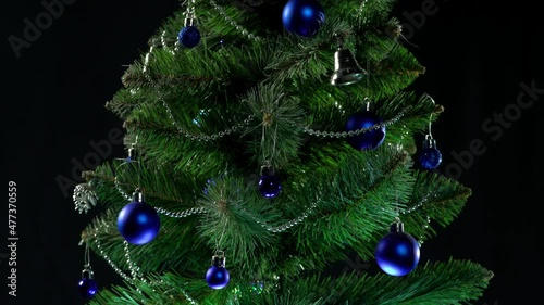 beautiful green christmas tree with garlands and gifts
