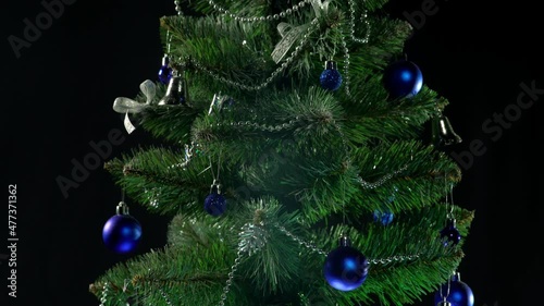 beautiful green christmas tree with garlands and gifts