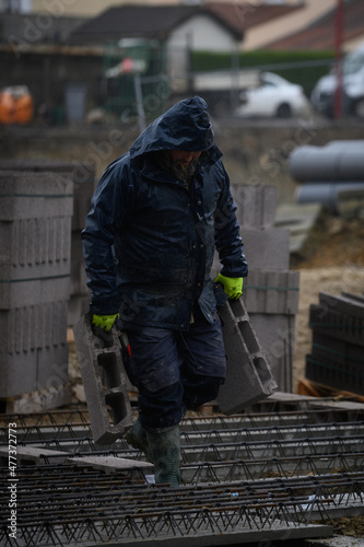 Man working on a construction site under the rain
