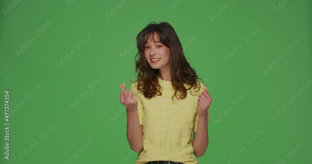Smiling young girl showing money gesture, beg payment, financial help, ask donation on chromakey green background Smiling young girl showing money gesture, beg payment, financial help, ask donation on chromakey green background
