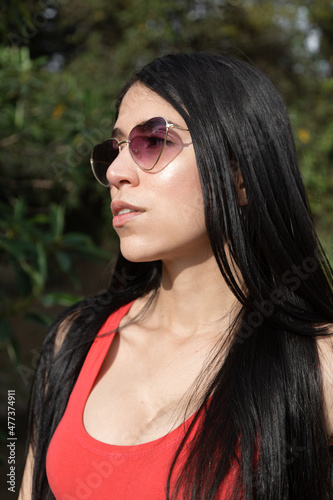 face of attractive latin young woman with straight black hair, wears fashionable sunglasses as accessory, natural beauty of model © Alejandro