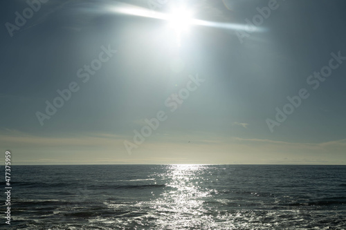 Horizontal photo, with reflection of the sun on the sea at Senhora da Hora beach in Portugal