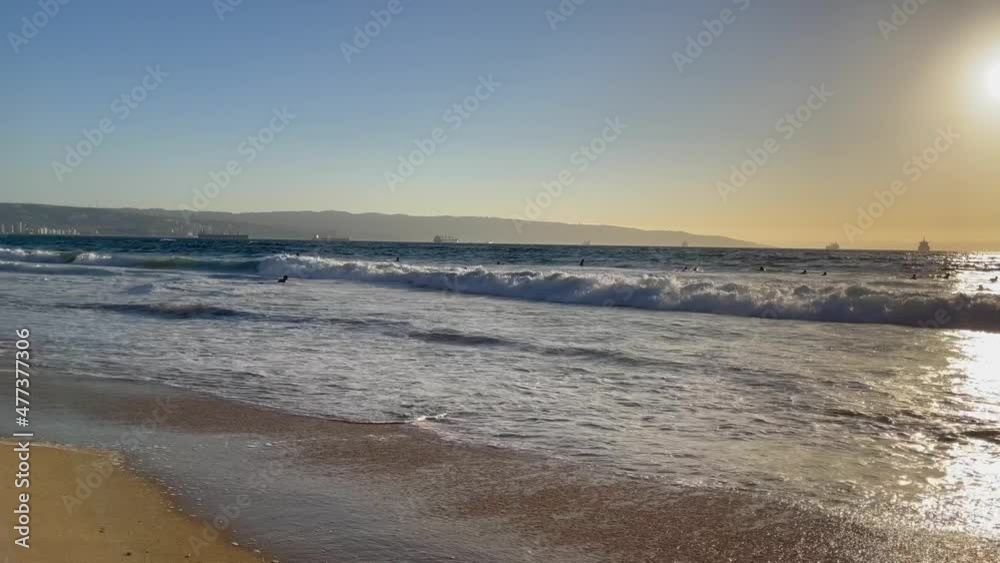 Group of bodyboarders and surfers enjoying waves at sunset over sea in Reñaca beach, Chile Group of bodyboarders and surfers enjoying waves at sunset over sea in Reñaca beach, Chile