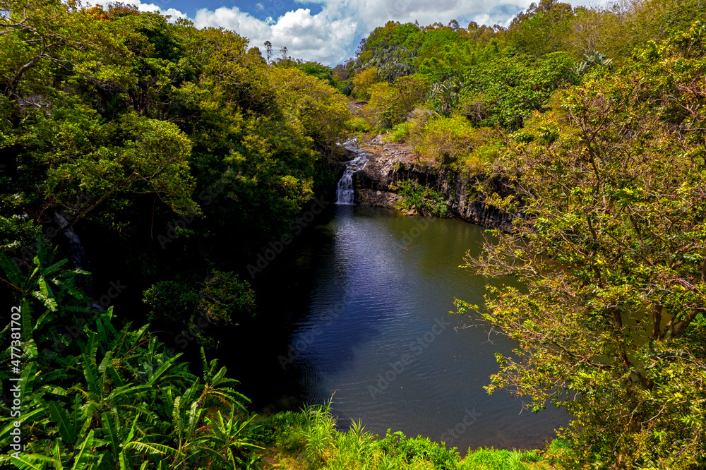 Aerial view of a waterfall hidden in a forest which is located near an old factory in Mauritius
