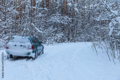 A lone car in snowy forest road