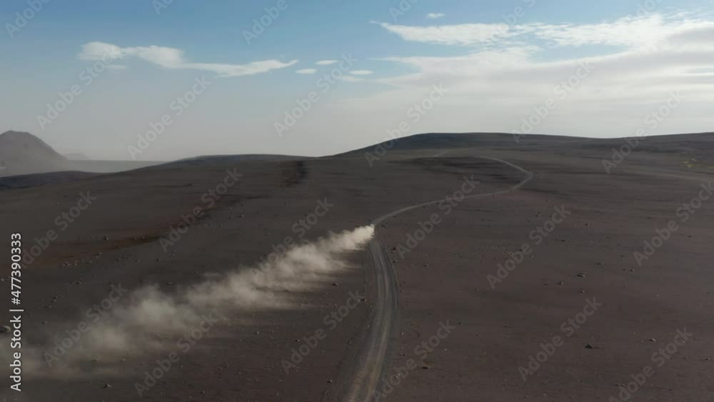 Top view of majestic Iceland landscape with car driving rock highlands. High angle view car driving fast motorway stirring up dust cloud. Insurance commercial Top view of majestic Iceland landscape with car driving rock highlands. High angle view car driving fast motorway stirring up dust cloud. Insurance commercial