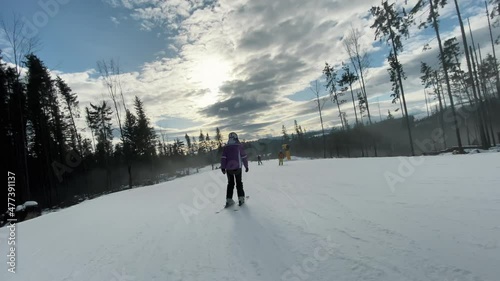 Skiers going downhill in a ski resort, active rest in winter mountains, extreme shooting in motion