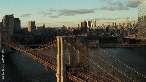Heavy traffic on Brooklyn Bridge lit by bright sun. Business skyscrapers in background. Manhattan, New York City, USA
