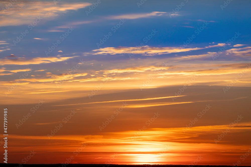 Bright warm sun on sky background. Dawn or sunset.