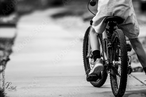 Wallpaper Mural Back view of a boy riding bicycle on road in grayscale Torontodigital.ca