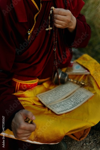 Close-up shot of a Buddhist monk holding prayer beads photo