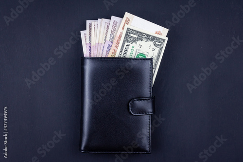 Different currencies in leather wallet photo
