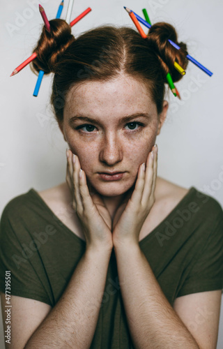 Portrait of young woman in green top with two buns hairstyle