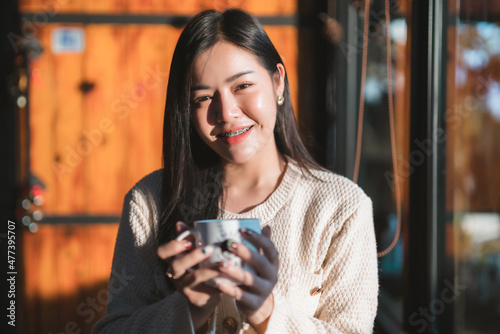 Portrait beautiful young asian woman girl wearing warm clothes enjoys drinking holding of positive the having cup of coffee milk or chocolate at house home in the living room inside or cafe