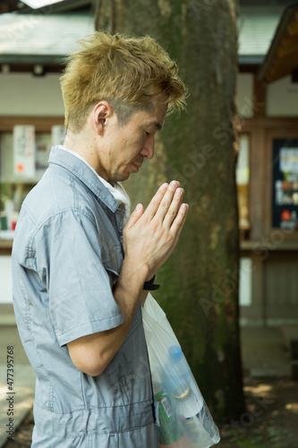 Side view of man in work suit praying photo