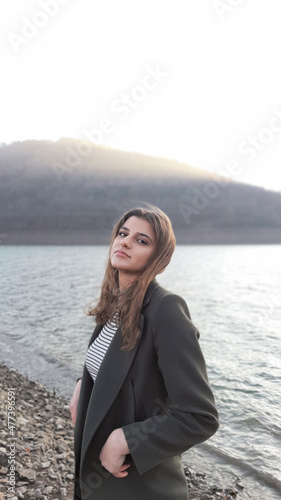 Woman in gray blazer standing on beach photo