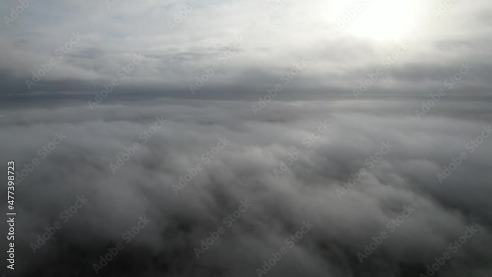 Aerial pan view above fog low level cloud sun bursting through Aerial pan view above fog low level cloud sun bursting through