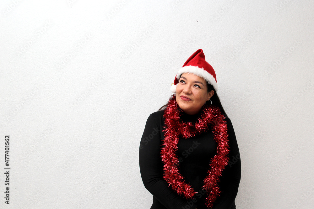 Latin adult woman with hat and Christmas garland shows her enthusiasm and happiness for celebrating Christmas and the new year
Latin adult woman with hat and Christmas garland shows her enthusiasm and happiness for celebrating Christmas and the new year