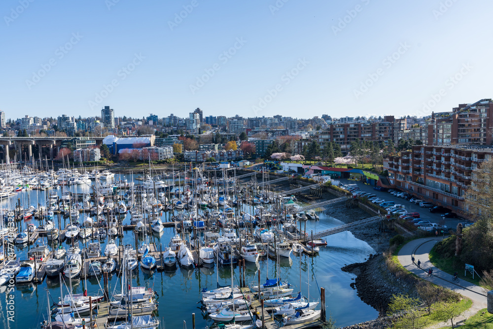 BC, Canada - April 4 2021 : Granville Island Marina Fishermens Wharf Float. Vancouver city buildings skyline. BC, Canada - April 4 2021 : Granville Island Marina Fishermens Wharf Float. Vancouver city buildings skyline.