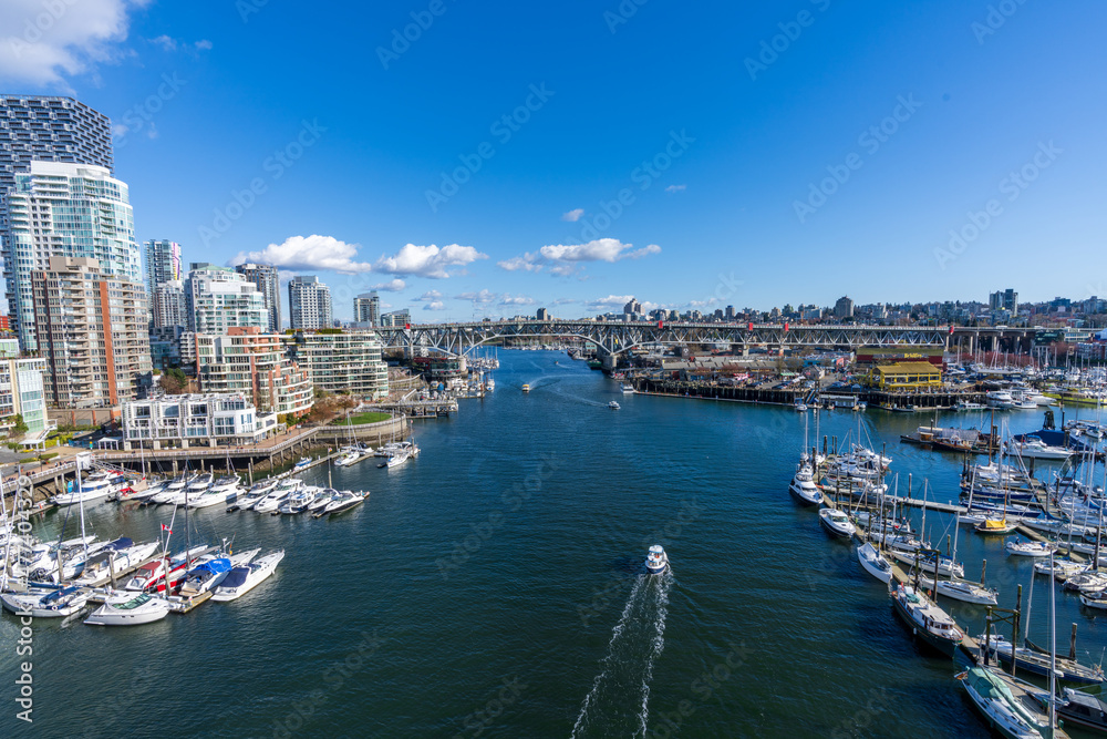 BC, Canada - April 4 2021 : Vancouver city skyline and Granville Island Marina. Granville Bridge.