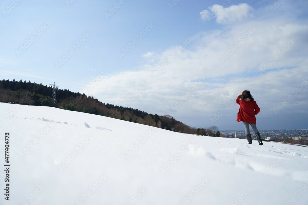 雪原を眺める赤いコートの女性