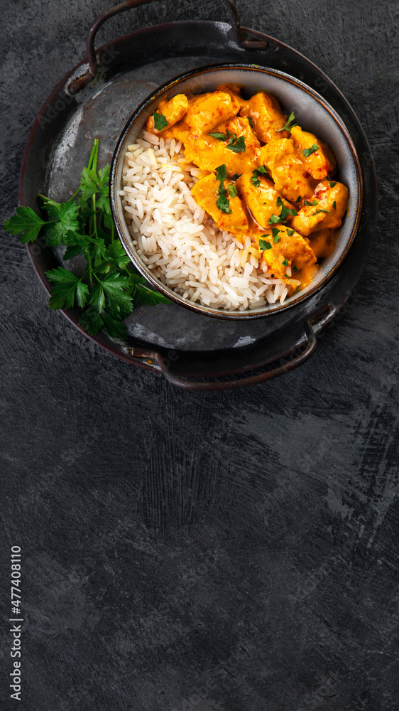 Indian butter chicken curry with basmati rice on dark background. Indian butter chicken curry with basmati rice on dark background.