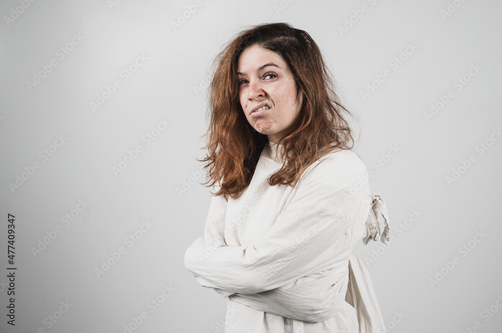 Close-up portrait of insane woman in straitjacket on white background.