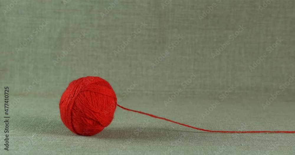 Thread ball on the floor. A view of a red ball from threads rolling on the floor.