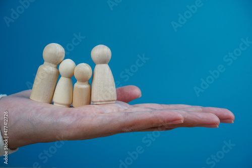 Family concept. wooden icons as a family on a woman palm