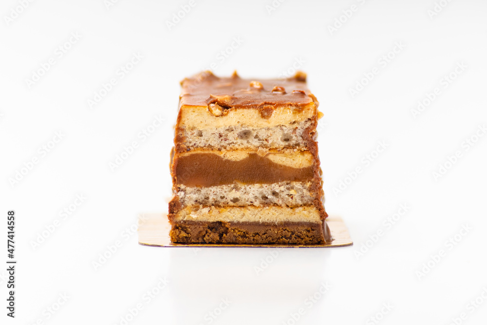 Sweet cake with salted caramel with biscuit layers on white background Sweet cake with salted caramel with biscuit layers on white background