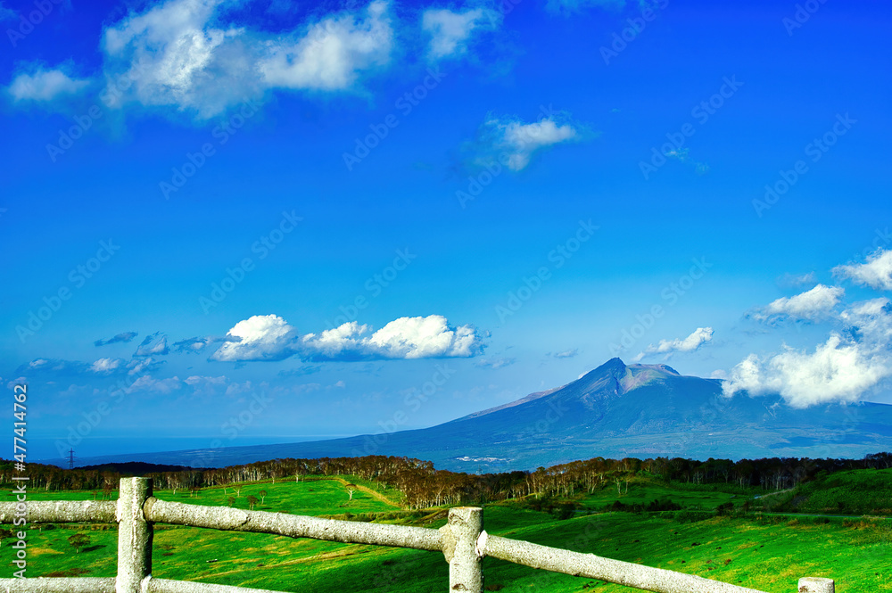 北海道の高原から見渡す青空と大きな山の景色