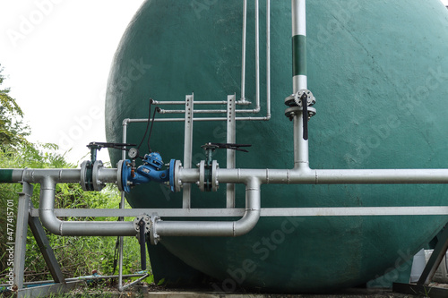 The joints and steel pipes transporting water up to a large water tank.