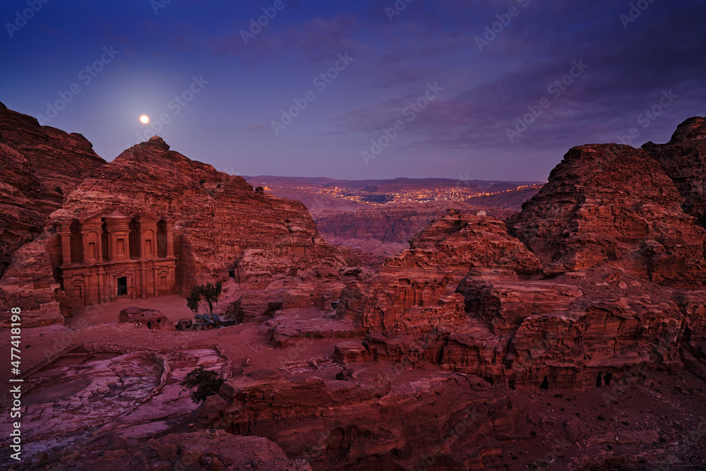Petra historical sight - Ad Deir Monastery with full moon during the night. Evening light in nature. Travel in Jordan, Arabia in Asia. Stone Monastery in rock, Petra in Jordan. Red rock landcape.