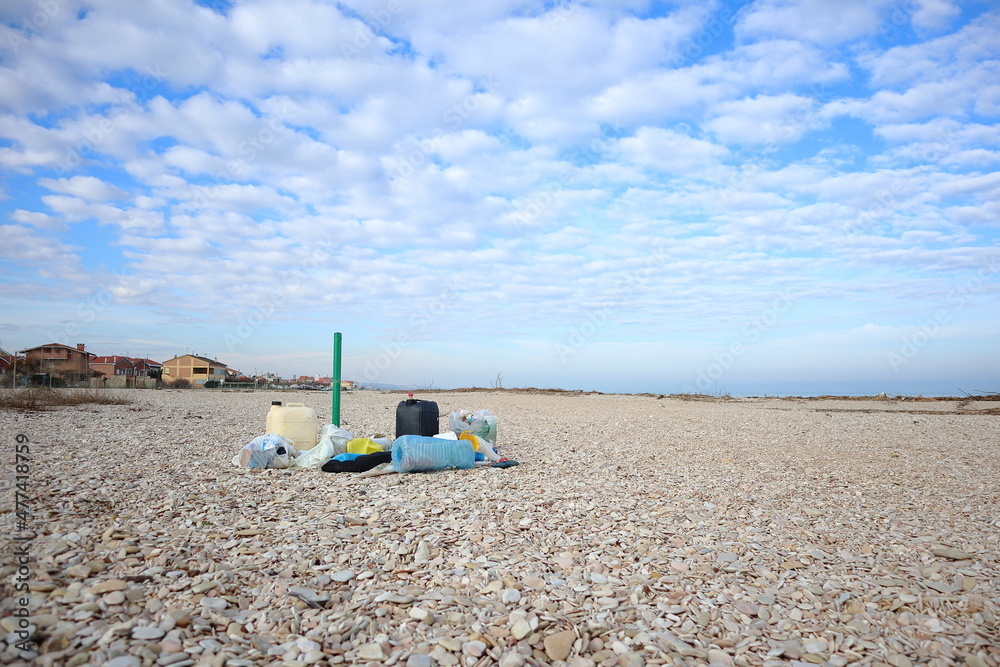 jerry cans and old plastic containers abandoned on the beach, pollution concept