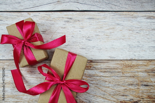 Gift boxes with pink ribbon on wooden background