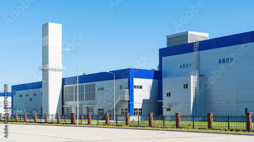Plant building from sandwich panels close-up. Logistic center exterior. Industrial building of engineering plant in sunny day.