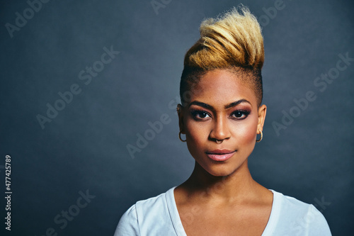 Portrait Of a confident Young Female Hipster with cool short hair and trendy nose ring and earrings