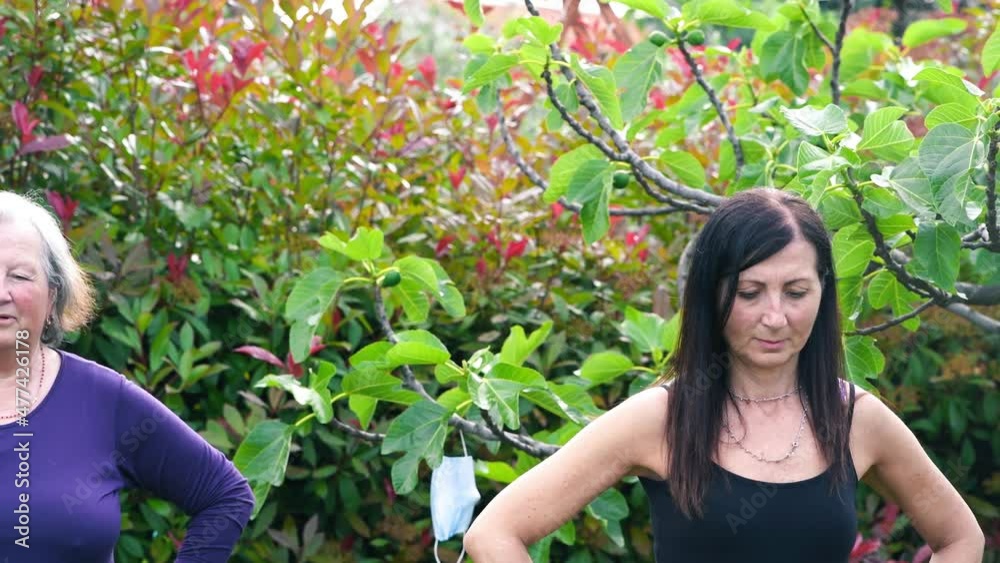 Four women having fitness outdoor with face mask hanging from the trees Four women having fitness outdoor with face mask hanging from the trees
