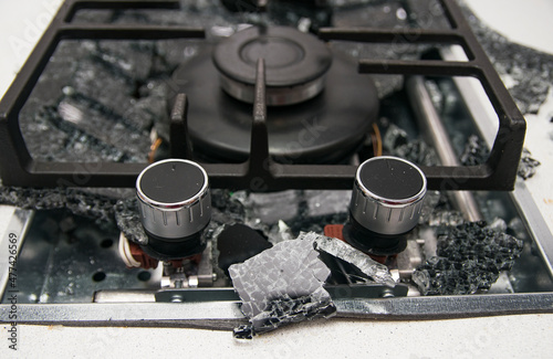 Debris from the explosion of a built-in gas hob in a glass ceramic hob in a kitchen photo