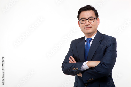 Middle aged business man posing with arms crossed on white background with studio shot