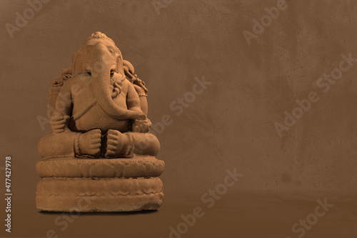 Selective focus on statue of Lord Ganesha, Ganesha Festival. Hindu religion and Indian celebration of Diwali festival concept on dark, red, yellow background.